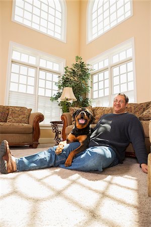 Portrait of Mature Man with his Pet Rottweiler in Living Room Photographie de stock - Premium Libres de Droits, Code: 600-07368545