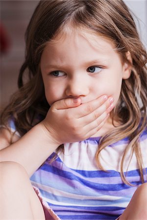 serious little girl - Close-up of Girl with Hand covering her Mouth Photographie de stock - Premium Libres de Droits, Code: 600-07363885