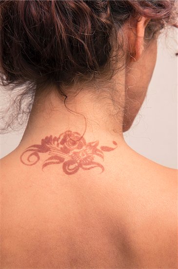 Close-up of woman's back and neck showing detail of henna painted tattoo in arabic style, studio shot on white background Stock Photo - Premium Royalty-Free, Artist: Bettina Salomon, Image code: 600-07434937