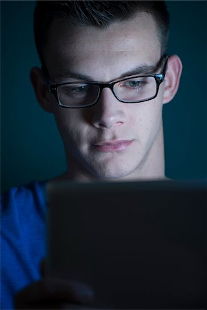 plugged in - Young Man looking at Tablet Computer, Studio Shot Stock Photo - Premium Royalty-Free, Code: 600-07431247
