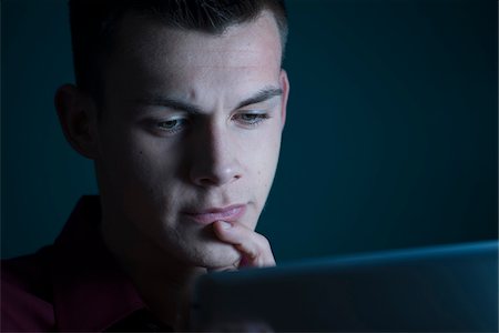 simsearch:700-06962024,k - Young Man looking at Tablet Computer, Studio Shot Stock Photo - Premium Royalty-Free, Code: 600-07431251