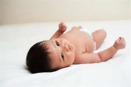 simsearch:600-07453971,k - Newborn Asian baby in diaper, looking up at camera, studio shot on white background Foto de stock - Sin royalties Premium, Código: 600-07453948