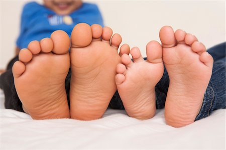 simsearch:633-08150976,k - Brother and sister lying in bed together, close-up of the soles of their feet, studio shot Stock Photo - Premium Royalty-Free, Code: 600-07453968