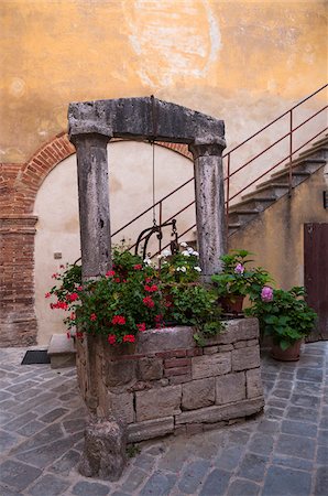 potted plants on stones - Old Well in courtyard, San Quirico d'Orcia, Val d'Orcia, Province of Siena, Tuscany, Italy Stock Photo - Premium Royalty-Free, Code: 600-07487410