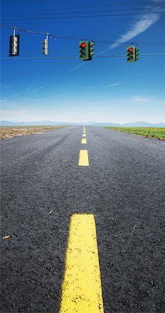 Close-up view of yellow, broken center line on deserted highway, with red traffic lights hanging on wires across road, Canada Foto de stock - Sin royalties Premium, Código: 600-07529014