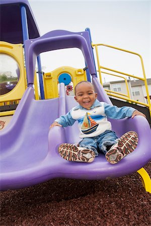 Portrait of Boy Playing on Playground Slide, Maryland, USA Stock Photo - Premium Royalty-Free, Code: 600-07529157