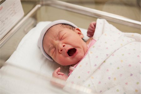 simsearch:600-07529193,k - Newborn Baby Girl Yawning in Hospital Bassinet Stock Photo - Premium Royalty-Free, Code: 600-07529212