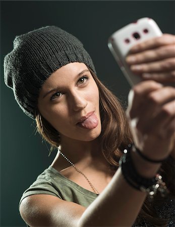 sortir la langue - Portrait of Teenage Girl taking Selfie with Cell Phone, Studio Shot Photographie de stock - Premium Libres de Droits, Code: 600-07562454