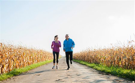 simsearch:600-07237885,k - Adult couple running on country road, Germany Stock Photo - Premium Royalty-Free, Code: 600-07584746