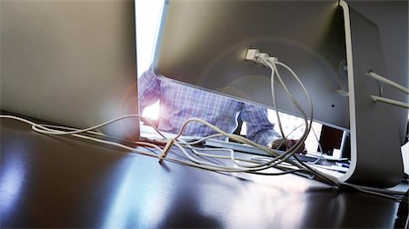 simsearch:600-06368307,k - Close-up of man working at desk with backview of computers and assorted wires, Canada Stock Photo - Premium Royalty-Free, Code: 600-07672336