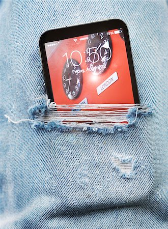 Close-up view of ripped pair of jeans with cell phone sticking out, Canada Stock Photo - Premium Royalty-Free, Code: 600-07672337