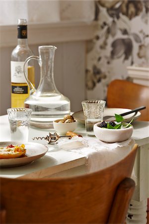 Dining Room Table with Bottle of White Wine, Jug of Water, Corkscrew and Bowls of Blackberries and Duck Eggs Stock Photo - Premium Royalty-Free, Code: 600-07784049