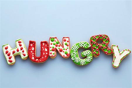 Overhead View of Christmas Sugar Cookies spelling HUNGRY on Blue Background Stock Photo - Premium Royalty-Free, Code: 600-07784425