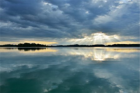 Clouds and crepuscular sunrays refelcted in lake at sunrise, Woerthsee Lake, Upper Bavaria, Fuenfseenland, Germany Photographie de stock - Premium Libres de Droits, Code: 600-07784606