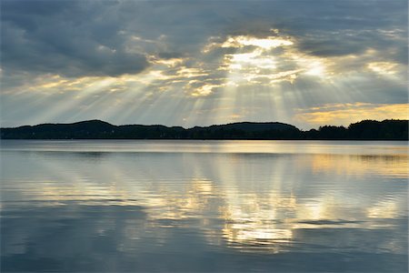 Clouds and crepuscular sunrays refelcted in lake at sunrise, Woerthsee Lake, Upper Bavaria, Fuenfseenland, Germany Photographie de stock - Premium Libres de Droits, Code: 600-07784607