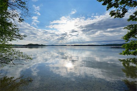 simsearch:600-06334268,k - Blue sky, clouds and sun reflected in lake, Lake Woerthsee, Bavaria, Germany Stock Photo - Premium Royalty-Free, Code: 600-07784611