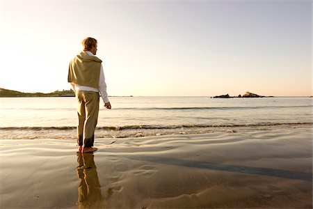 foreground - A man pauses while skipping rocks into the water at Bailey's Beach on an autumn morning, Newport, Rhode Island, USA. Stock Photo - Premium Royalty-Free, Code: 600-07945074
