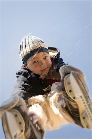 fond (bas) - Portrait of a young boy on ice skates looking through a frozen pond in Newport, Rhode, Island, USA. Photographie de stock - Premium Libres de Droits, Code: 600-07945125
