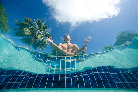 Man doing yoga poolside, view from underwater, Antigua, Caribbean Stock Photo - Premium Royalty-Free, Code: 600-07945145