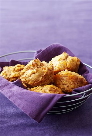 Cheddar muffins in a wire basket with a purple napkin, studio shot on purple background Photographie de stock - Premium Libres de Droits, Code: 600-08002089