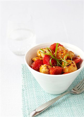 White bowl filled with sweet and sour chicken and red peppers on a turquoise napkin with a fork, studio shot on white background Photographie de stock - Premium Libres de Droits, Code: 600-08002126