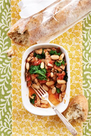patterned - Sausage, bean and kale stew with fork in a bowl and crusty bread, studio shot Stock Photo - Premium Royalty-Free, Code: 600-08002164
