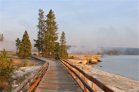 Boardwalk at West Thumb Geyser Basin with Steam from Hot Springs and Yellowstone Lake in the background, Yellowstone National Park, Wyoming, USA Stock Photo - Premium Royalty-Free, Code: 600-08002203