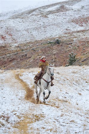 Young Cowboy riding horse in wilderness in snow, Rocky Mountains, Wyoming, USA Foto de stock - Sin royalties Premium, Código: 600-08026172