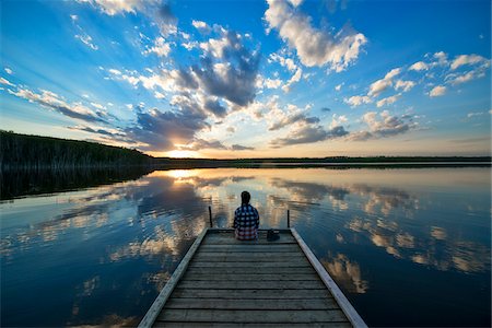 Hiker Sitting on Dock at Calm Lake at Sunset, Saskatchewan, Canada Photographie de stock - Premium Libres de Droits, Code: 600-08102819