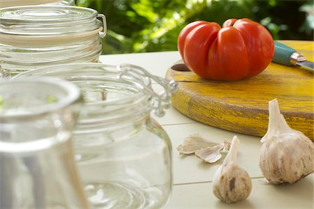 simsearch:600-06431322,k - Tomato on Cutting Board with Garlic and Glass Jars Stock Photo - Premium Royalty-Free, Code: 600-08209966