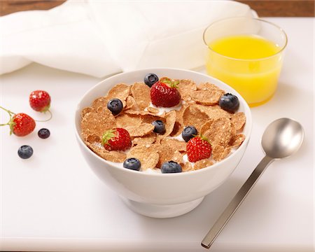 Bowl of Cereal Flakes with Berries and Orange Juice Stock Photo - Premium Royalty-Free, Code: 600-08212904