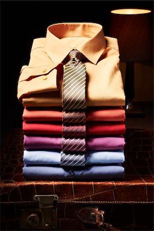 Stack of shirts with ties on suitcase in studio Photographie de stock - Premium Libres de Droits, Code: 600-08312066