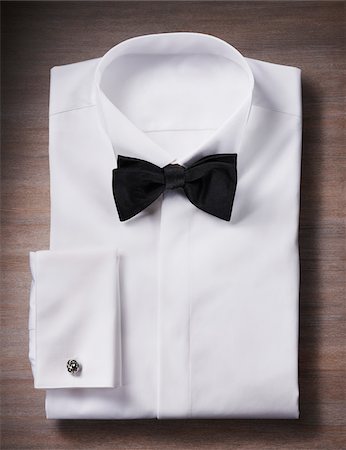 simsearch:600-08542899,k - White, tuxedo shirt with a bow tie and cuff link, studio shot on wooden background Stock Photo - Premium Royalty-Free, Code: 600-08353424