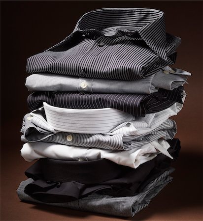 Stack of men's dress shirts on brown background Stock Photo - Premium Royalty-Free, Code: 600-08542910