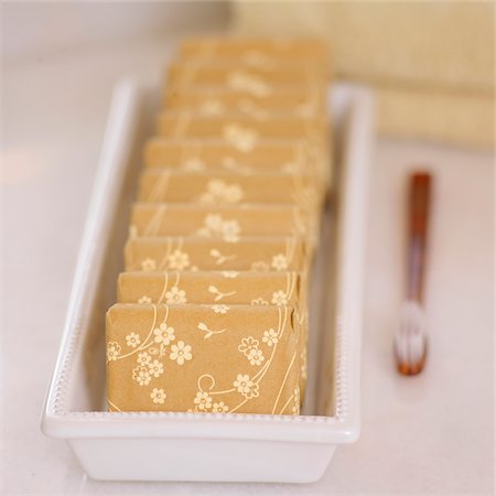 simsearch:600-07066872,k - Close-up of Floral Wrapped Bars of Soap in Dish with Towels and Toothbrush Stock Photo - Premium Royalty-Free, Code: 600-08559839