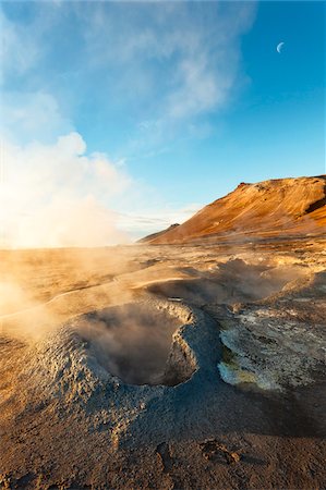 sunlit - Sunlit mist rising from the Hverir Hotsprings on Namafjall with the moon in the blue sky, Northeast Iceland Stock Photo - Premium Royalty-Free, Code: 600-08765599