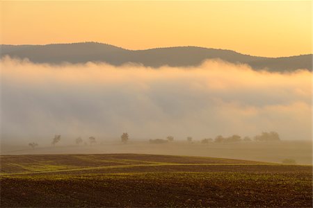 simsearch:600-08973341,k - Countryside with morning mist over fields illuminated by the sun at Grossheubach in Bavaria, Germany Stockbilder - Premium RF Lizenzfrei, Bildnummer: 600-08973342