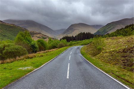 Winding country road and hills with overcast sky at Glen Nevis near Fort William in Scotland, United Kingdom Fotografie stock - Premium Royalty-Free, Codice: 600-08973423
