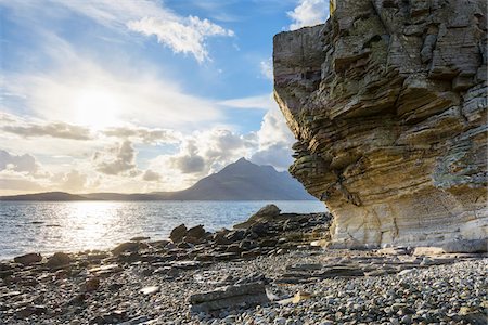 Rock face of sea cliff with honeycomb weathering and sun shining over Loch Scavaig on the Isle of Skye in Scotland, United Kingdom Photographie de stock - Premium Libres de Droits, Code: 600-08986269