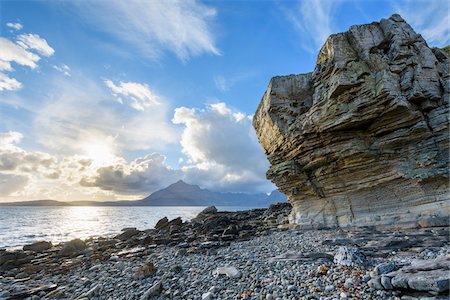Rock face of sea cliff with honeycomb weathering and sun shining over Loch Scavaig on the Isle of Skye in Scotland, United Kingdom Stock Photo - Premium Royalty-Free, Code: 600-08986274