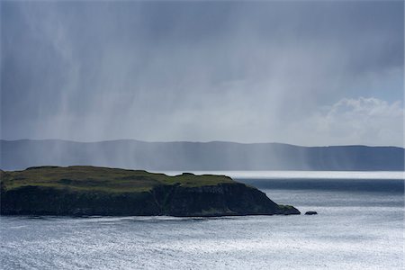 Sunlit sea cliffs and rainclouds along the coast of the Isle of Skye in Scotland, United Kingdom Stock Photo - Premium Royalty-Free, Code: 600-08986460