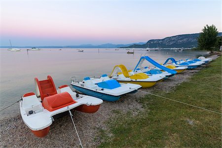 Row of colorful pedal boats on the beach at dawn on Lake Garda (Lago di Garda) at Bardolino in Veneto, Italy Foto de stock - Sin royalties Premium, Código: 600-09022416