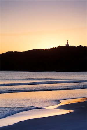 pacific coast - Silhouette of Cape Byron Lighthouse and sunlit beach at sunset at Byron Bay in New South Wales, Australia Stock Photo - Premium Royalty-Free, Code: 600-09022565