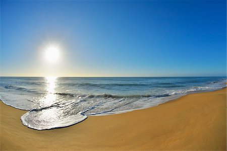 simsearch:600-09052847,k - Surf breaking on the shoreline of Ninety Mile Beach at Paradise Beach with the sun shining over the ocean in Victoria, Australia Foto de stock - Sin royalties Premium, Código: 600-09052847