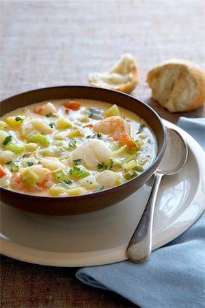 Bowl of seafood chowder soup with a spoon and crusty bread Photographie de stock - Premium Libres de Droits, Code: 600-09118292