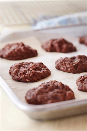 simsearch:600-09119379,k - Freshly baked chocolate cookies on a cookie sheet with parchment paper Stock Photo - Premium Royalty-Free, Code: 600-09119363