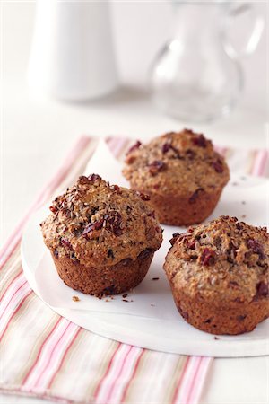 Cranberry flaxseed muffins on a white plate with a striped napkin Photographie de stock - Premium Libres de Droits, Code: 600-09119415