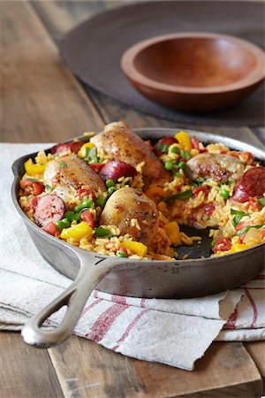 Skillet of chicken, rice and chorizo on a striped napkin Foto de stock - Sin royalties Premium, Código: 600-09119438