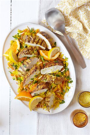 Platter of sliced chicken breast on couscous with orange and lemon slices Stock Photo - Premium Royalty-Free, Code: 600-09119443