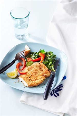 Sesame seed crusted chicken breast with spinach salad and red peppers on a blue plate Stock Photo - Premium Royalty-Free, Code: 600-09119469